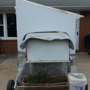 Winterized tractor from the side.  Insulated tarp over box, my flower box of chives holding down the bottom plastic.