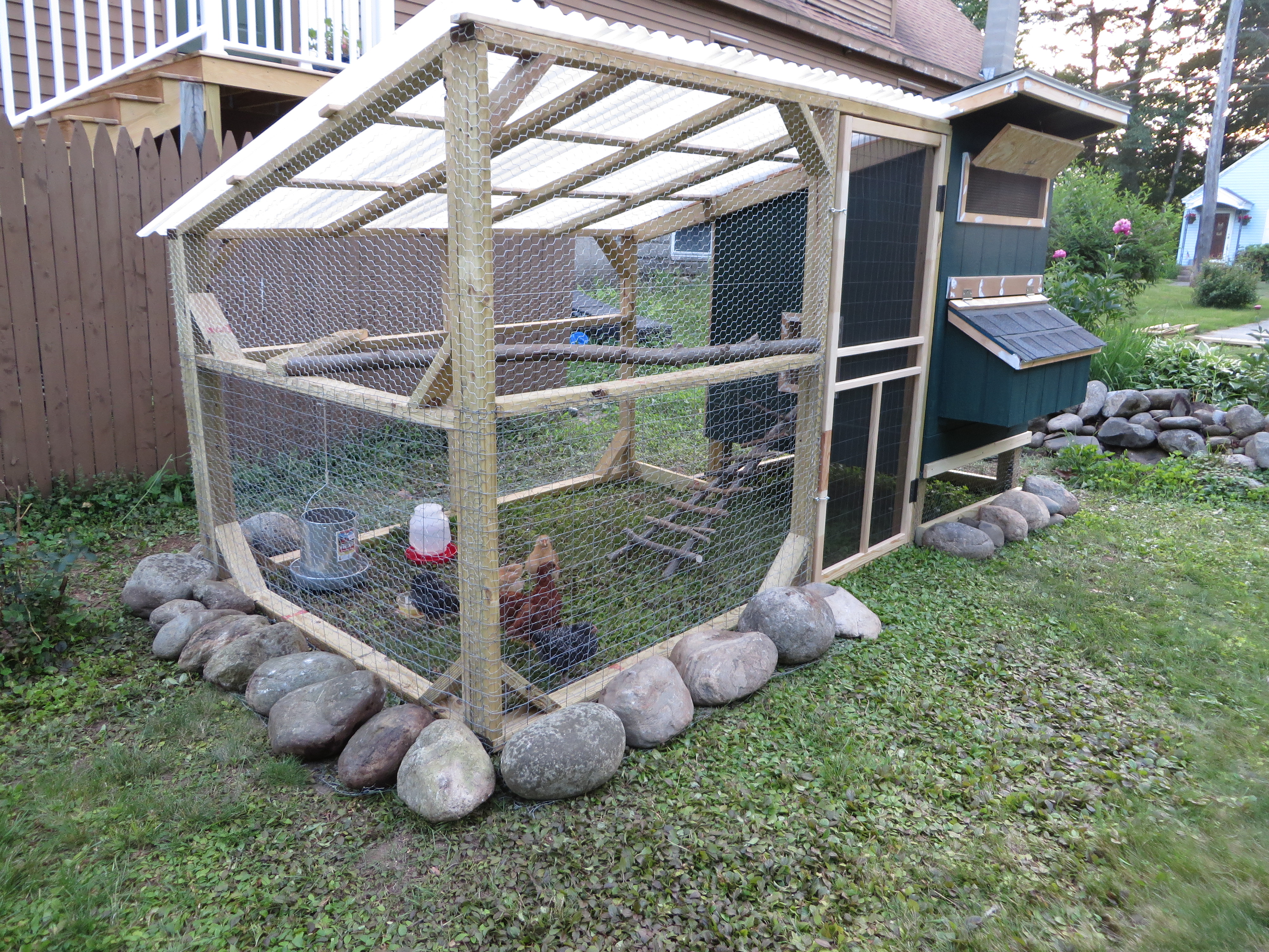 The door to the run is a pre-made screen door that I bought for $20 and cut about 10" off the top to fit the run. I also added 2"x3" wire to the door. The run is fully covered with chicken wire, including a 1' wide apron under the stones. The lower half of the run also has 2"x3" fencing. The roof of the run us white corrugated plastic roofing panels.